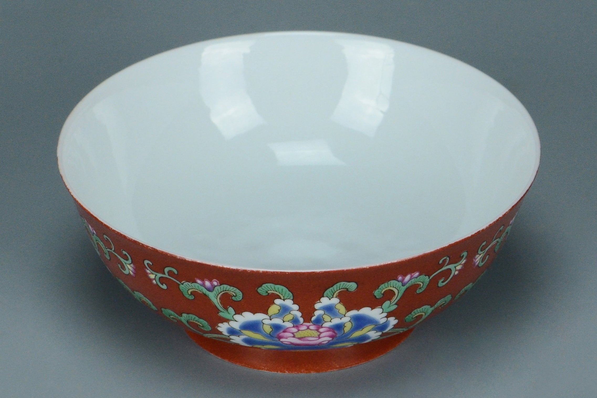 R121: A CHINESE QING DYNASTY STYLE CORAL GROUND FAMILLE VERTE BOWL QIANLONG MARK