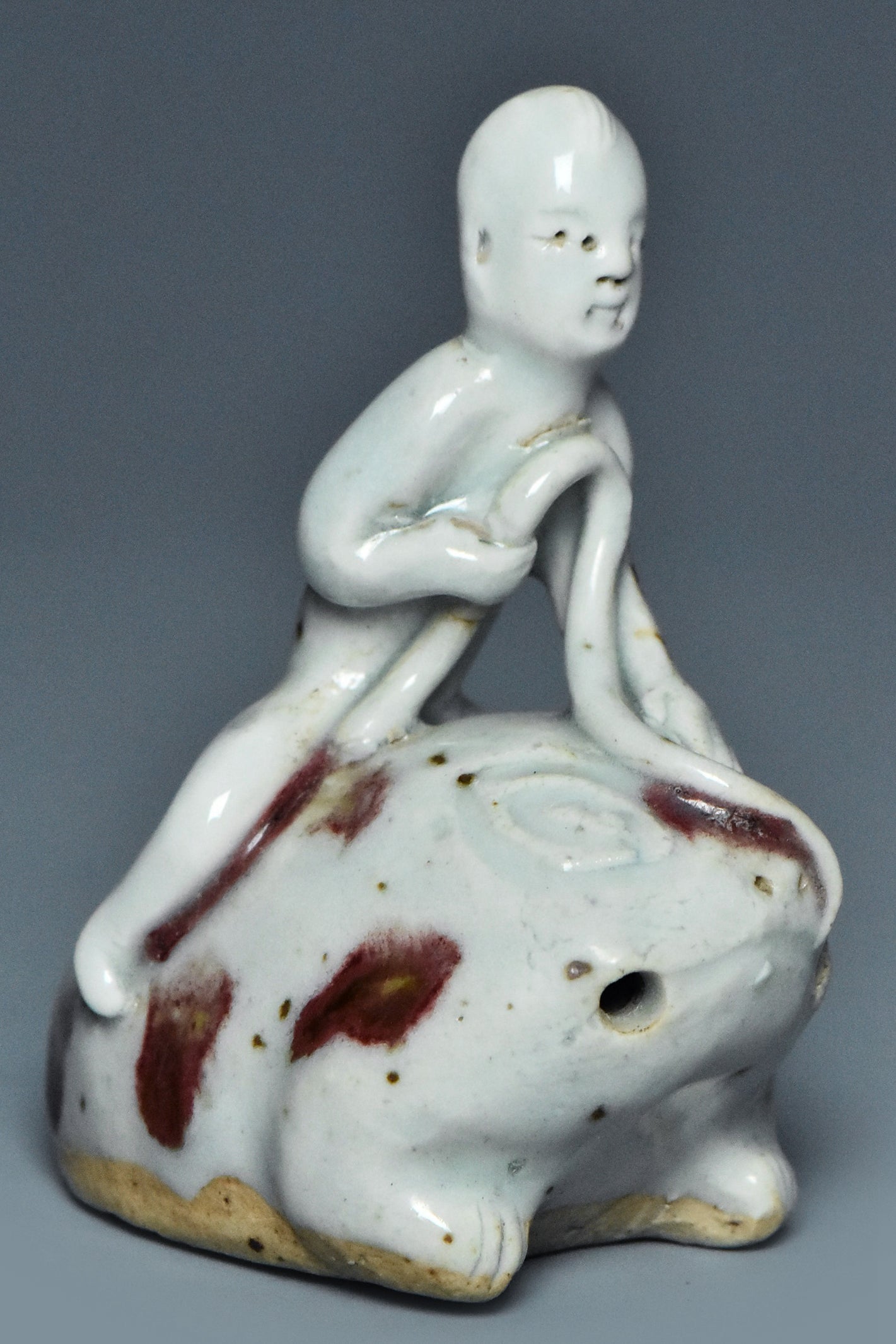 R346: A YUAN DYNASTY STYLE COPPER RED DECORATED FIGURE OF A BOY ON A FROG